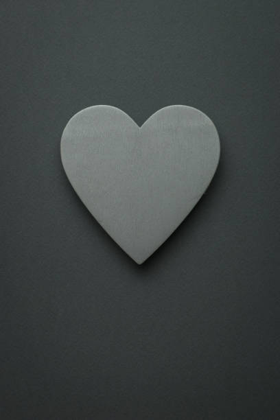 istock Light gray wooden heart on a black background. Space for text. 1361824285