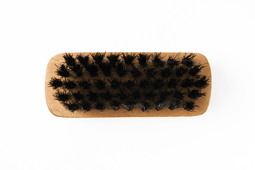 Close-up of shoe brush with black bristle on white background.