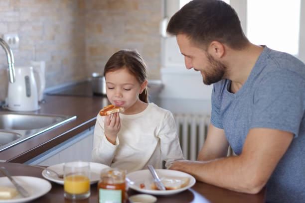 istock Father and daughter having breakfast at home 1361836318