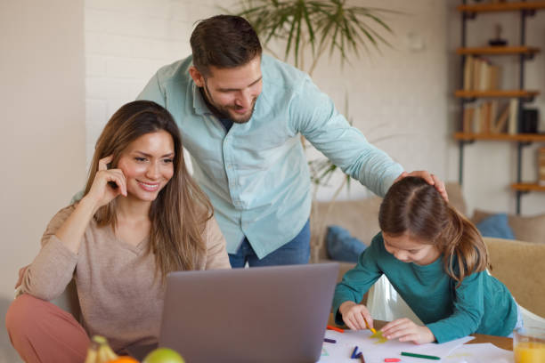 istock Parents doing homework with their daughter at home using laptop 1361836331