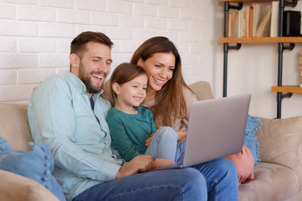istock Smiling family relaxing at home and using laptop together 1361836964