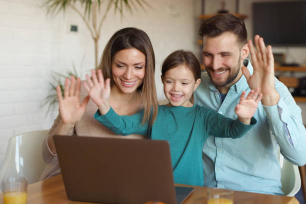 istock Happy family using laptop and making video call at home 1361837017