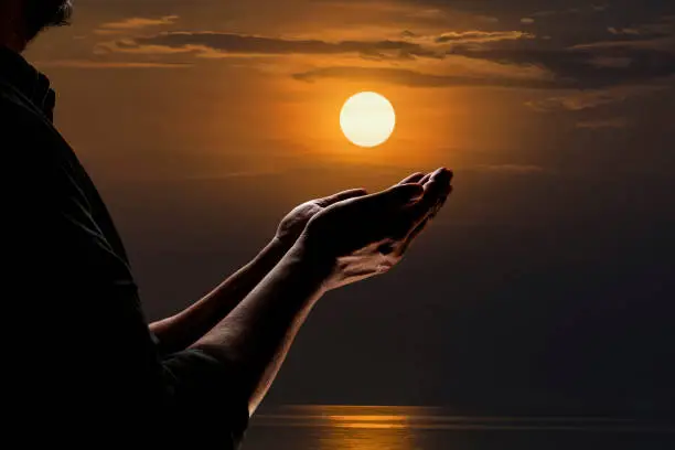 Photo of A Muslim man prays to the Lord's blessing at the riverside on a full moon night.