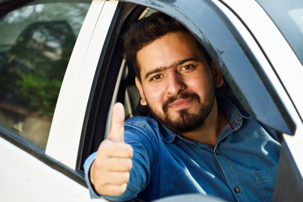 Indian Man Showing Thumbs Up From New Car stock photo
