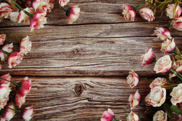 istock Pink roses flowers border frame on wooden background 1361842694
