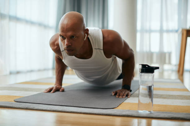 istock Young African American male athlete doing push-ups during home workout. 1361843690