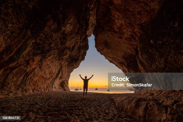 Unrecognizable Man At Cala Luna Cave At Sunset Gulf Of Oroseisardinia Italy Stock Photo - Download Image Now