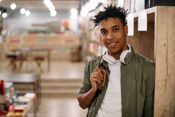 istock Portrait of young black student at university library looking at camera. 1361844784