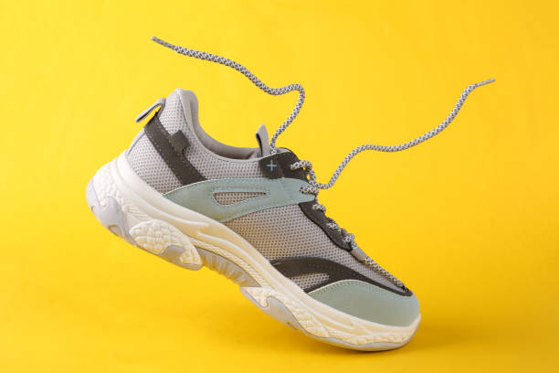 istock Sports sneaker with flying laces on a yellow background 1361851248