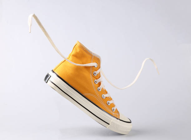 Classic old school sneaker with flying laces on gray background
