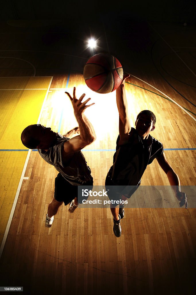 Tramonto silhouette di saltare due giocatori di basket - Foto stock royalty-free di Basket