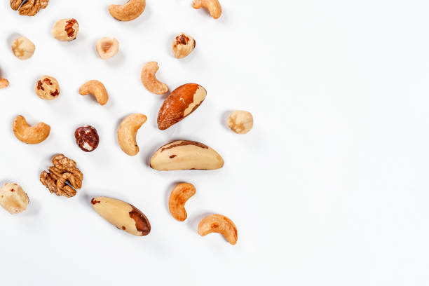 istock Different nuts are scattered on a white background. Walnuts, hazelnuts and Brazil nuts. The concept of healthy eating and snacking 1361857218