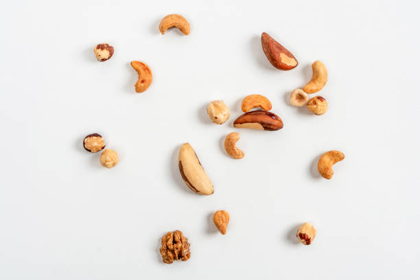 istock Different nuts are scattered on a white background. Walnuts, hazelnuts and Brazil nuts. The concept of healthy eating and snacking 1361857932