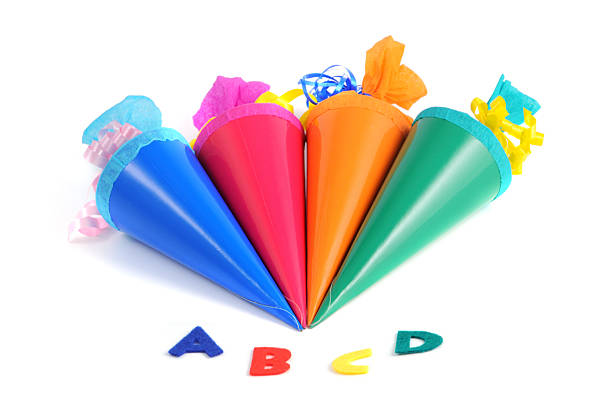 Conical bag of sweets Schultuete zur Einschulung - Conical bag of sweets with letters ABC in front. zuckertüte stock pictures, royalty-free photos & images