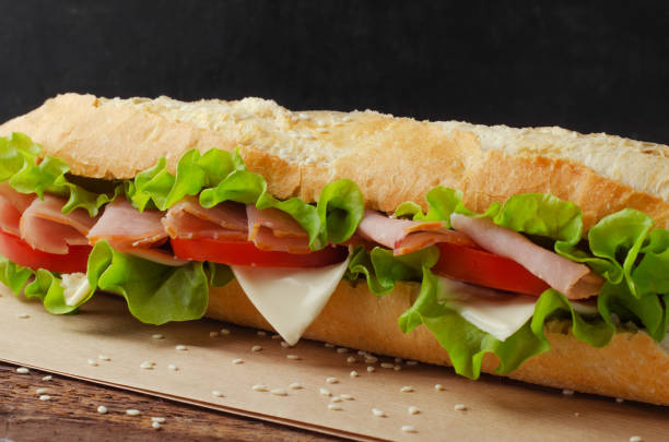 istock Sandwich with ham, tomato and cheese on a wooden background 1361861257