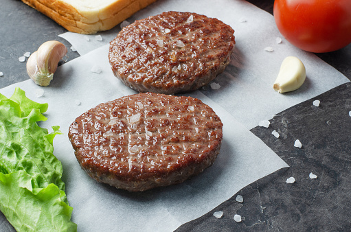 Home handmade cutlets for burgers with Ingredients on paper