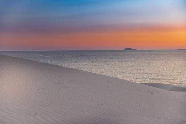 View of a desert beach with sand dunes at sunset, Sardinia, Italy.