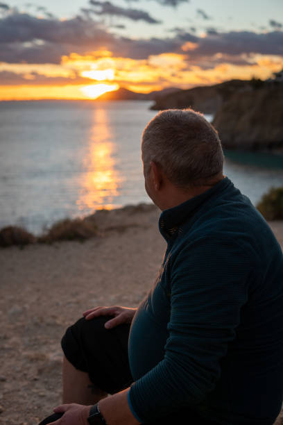 istock A man observing the sea sunset from the beach mountains 1361866273