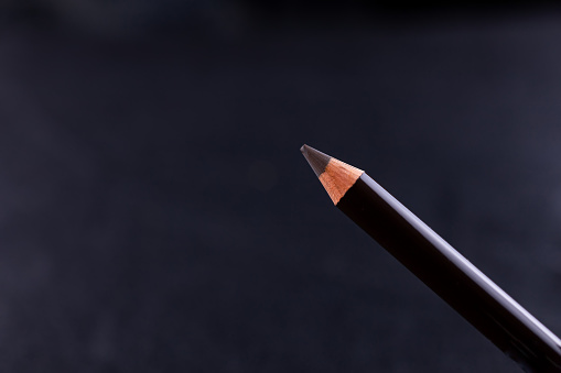 close-up of powdery eyebrow pencil on a black background