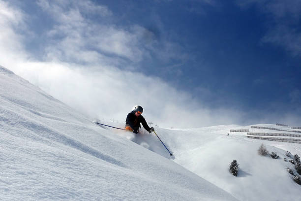 Male skier riding in the deep snow on a sunny day in the skiresort of St. Anton am Arlberg in Tirol, Austria