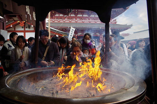 Asakusa,Tokyo Japan - January 1, 2015:Here is the Senso-ji Temple of New Year Day in Asakusa,Japan.Many Japanese people visit temple to pray for happiness and good health. The first prayer in a year is called the ’Hatsumoude’. Sensoji Temple is the oldest temple in Tokyo.This is a big incense burner. When we expose to the smoke of incense burner, it is said that the bad place of our body will have been healing.