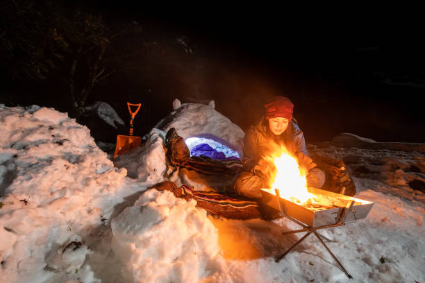 istock A woman warms her hands by campfire at her snow camp and igloo 1361870099