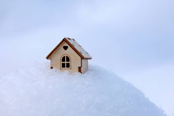 istock Wooden house model in a snow 1361872762