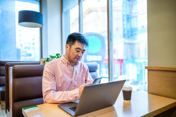 istock Asian middle-aged man using laptop in coffee shop 1361875945