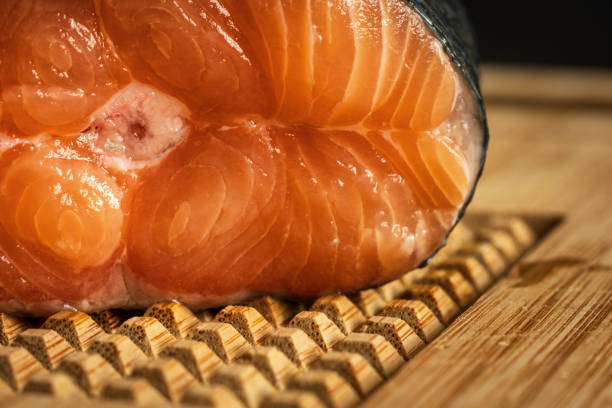 raw salmon filet on wooden cutting board