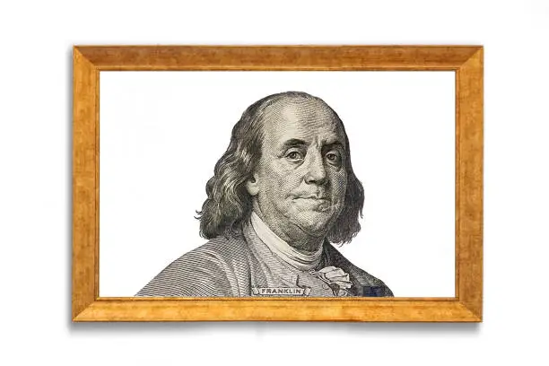 Benjamin Franklin cut on new 100 dollars banknote in golden picture frame