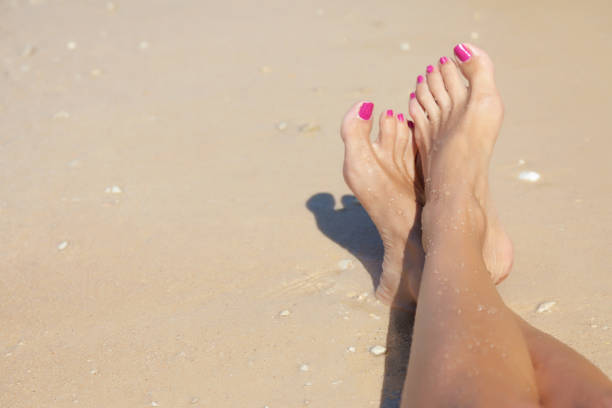 istock Women's feet by the sea 1361878966