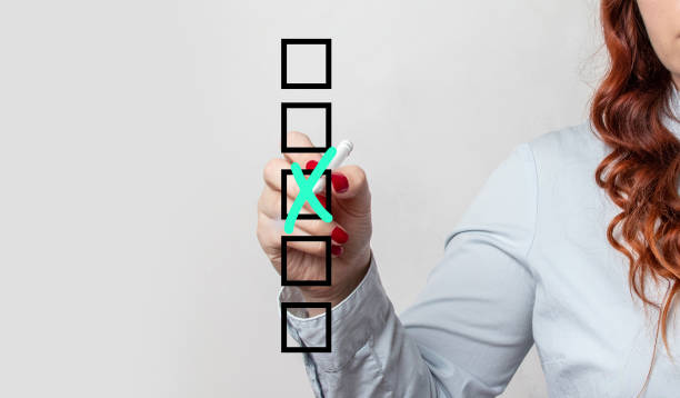 istock Marking on checklist box. Person ticking checkboxes with pen on checklist or to-do-list with copy space 1361880270
