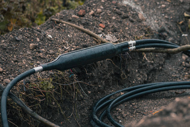 istock Industrial optical cable connection, Y split of a cable, shielded in a plastic enclosure seen dug up from the ground or trench at a construction site. 1361888929
