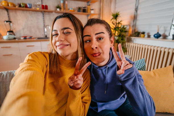 istock Young lesbian couple making silly selfie 1361890241