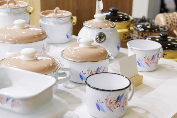 istock Industrial background. Various enameled modern tableware on a shop window. Household goods for the kitchen, pots, teapots, bowls, mugs 1361891938