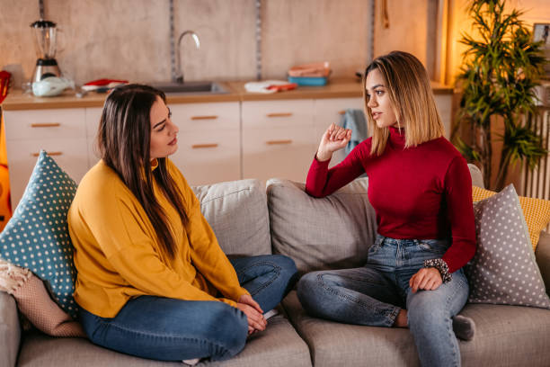 istock Young lesbian couple gossiping on sofa at home 1361892063