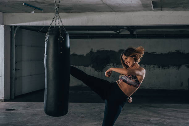 istock Young sportswoman doing high kick during boxing exercise in a garage. 1361893325