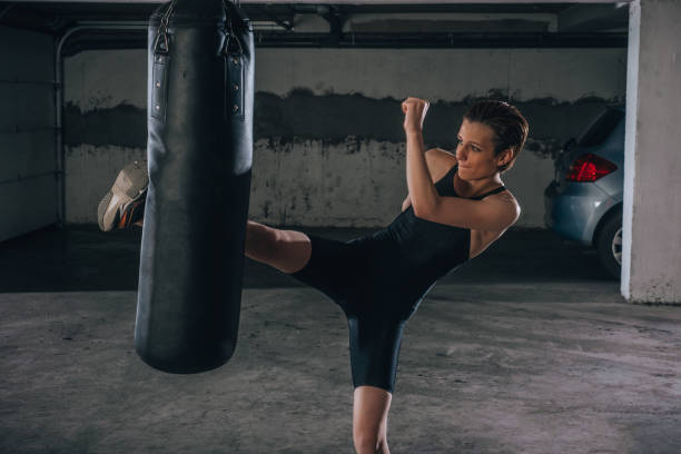 istock Young sportswoman doing high kick during boxing exercise in a garage. 1361893492