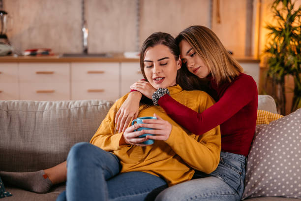 istock Lesbian couple spending good time together on sofa and drinking coffee 1361893870