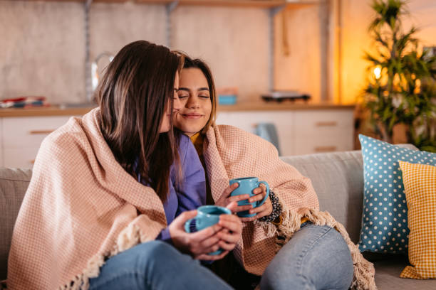 istock Lesbian couple spending good time together on sofa and drinking coffee 1361894900