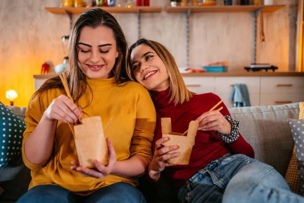istock Lesbian couple relaxing at home and eating pasta 1361894946