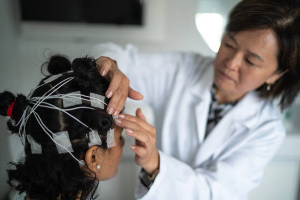 doctor placing electrodes on patient's head for a polysomnography (sleep study) - electrode imagens e fotografias de stock