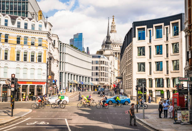 London, UK - Cyclists making up most of the traffic crossing an intersection in London's financial district, with the dome of St Paul's Cathedral on the horizon.
