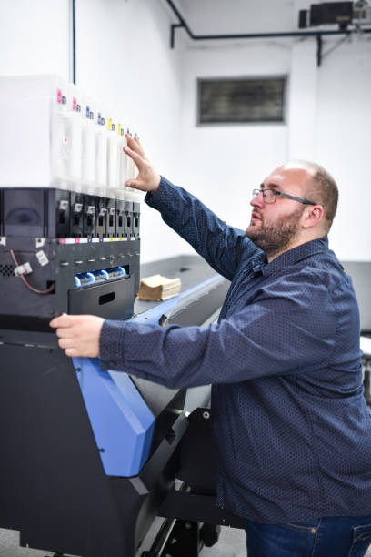 istock Bearded Male Textile Factory Foreman Explaining Printing Machine Usage 1361896785