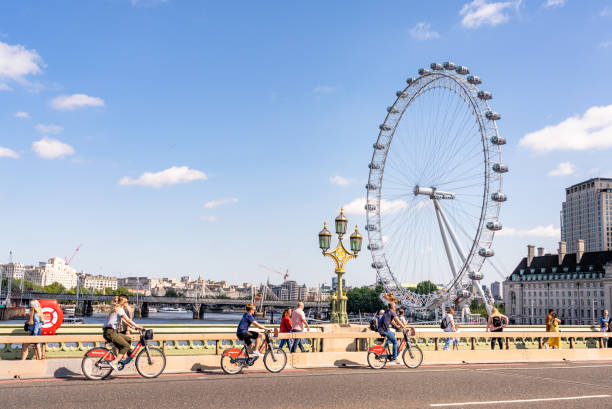 cyclistes sur le pont de westminster à londres - london eye photos et images de collection