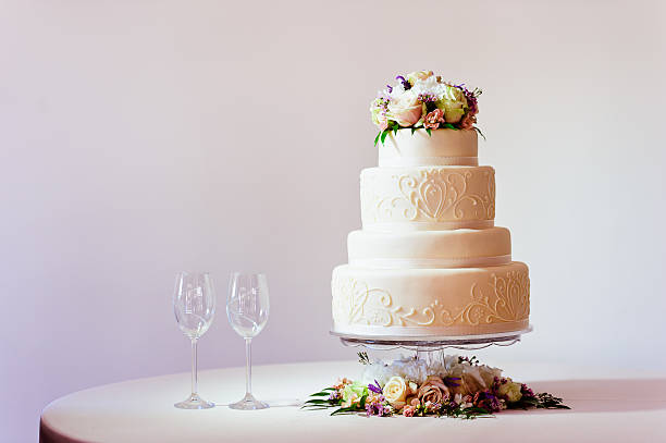 Wedding Cake Wedding cake with wine glasses on table. wedding cake stock pictures, royalty-free photos & images
