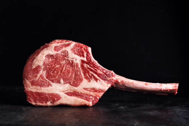 bistec de tomahawk fresco en tabla vieja - veal meat raw steak fotografías e imágenes de stock