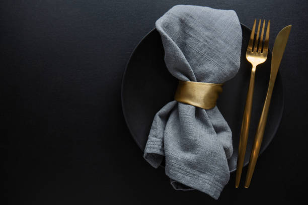 golden cutlery set with dark plate - eating utensil elegance silverware fine dining imagens e fotografias de stock