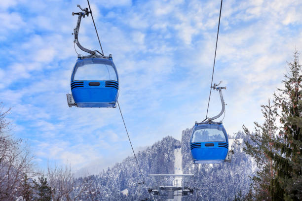 Bansko, Bulgaria winter ski resort with slope, lift gondola cabins, and sunset mountains view