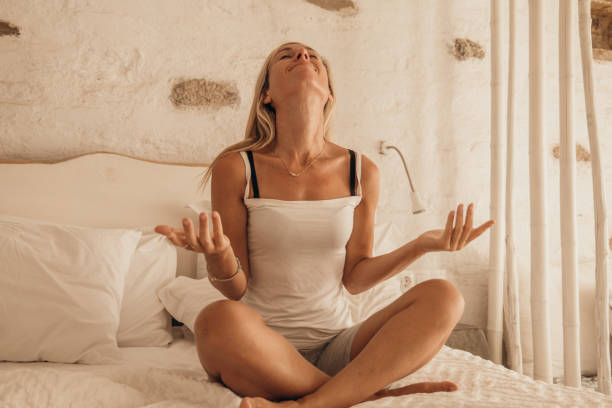 istock Beautiful young woman meditating in comfortable bed 1361903785